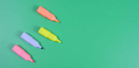 four colored markers on a green backgroundの写真素材