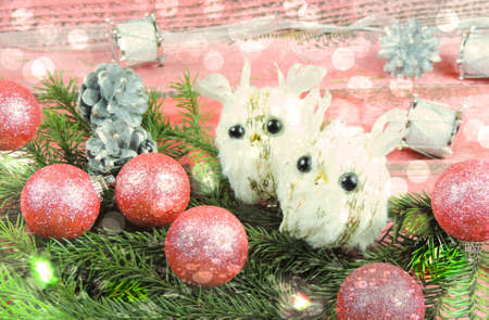 little white owl sitting on a Christmas tree near Christmas toys.の写真素材