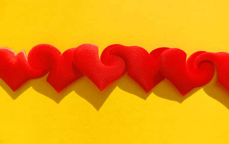 red hearts on yellow background with weave and merge effect, greeting valentine heart shape, concept of one mindの写真素材