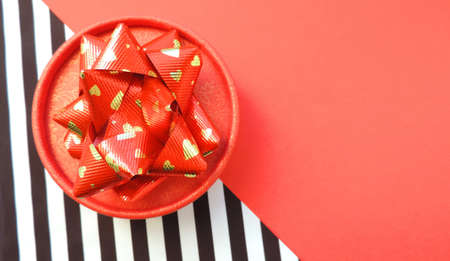 Red gift box with red bow on stripted background Holiday web banner. Top view. minimal christmas concept idea and creative thinking about love and Valentine's dayの写真素材