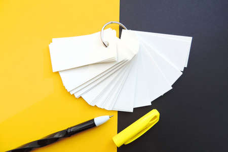 blank sheets of Notepad are held together with a metal ring, mockup, pen and black yellow background. Template with copy space, flat design, layout. Planning concept, education. Workspace.の写真素材