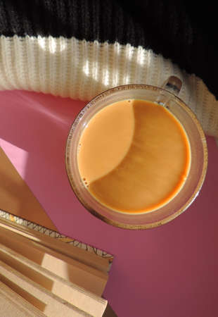 Flat lay with cup of coffee warm plaid and notebook. Sunset light and shadows. At home.
