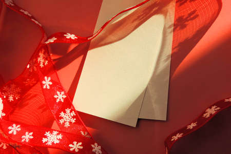 christmas red ribbons with snowflake ornament and blank sheet for text, Fashion shadow concept. overlay shadows and lights. Desktop, copy space.の写真素材