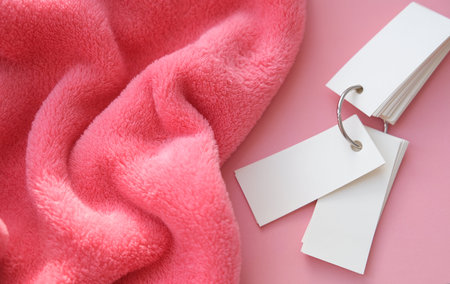 Pink delicate soft background of plush fabric folds on pink background and mini notepad Copy space....