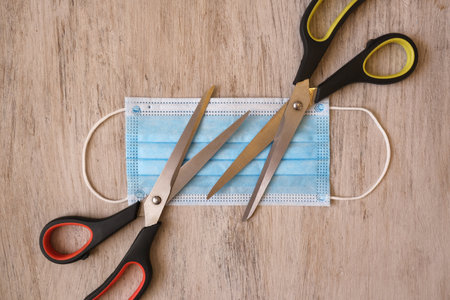 Medical protective face mask and scissors to cut or destroy mask that has been used before disposing of trash, prevent the sale of mask again during outbreak of Covid-19の写真素材