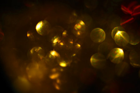 golden circular reflections christmas lights black backgroundの写真素材
