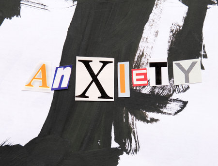 Word writing text anxiety from cut letters on abstract strokes black and white background. Headline - anxiety, card of psychology. Psychologic concept.の写真素材