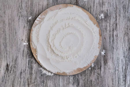 coarse flour on wooden round board on wooden background. copy space