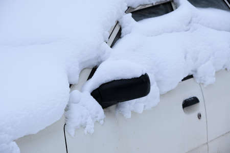 Car covered with snow in the parking after a snow stormの写真素材