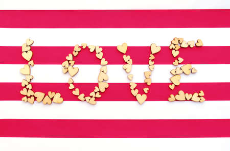 Word Love From Wodden Hearts on red white striped backgroundの写真素材
