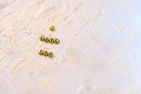 Partial blurred golden letters words i Love you on abstract solid background coating putty with...