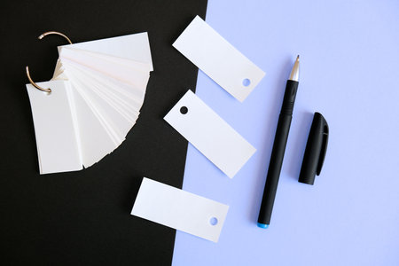 Two colored background and stack of blank sheets mockup tied with a metal ring, pen, copy spaceの写真素材