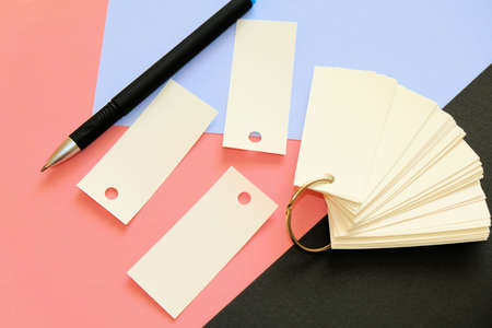 Multicolored background and stack of blank sheets mockup tied with a metal ring, pen, copy space