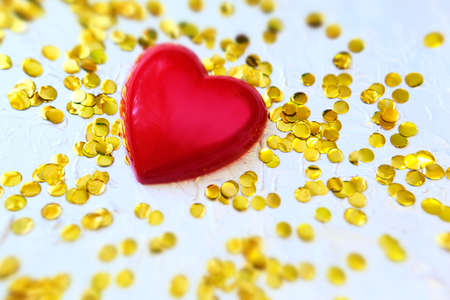 Blurred red heart and golden confetti, holiday background