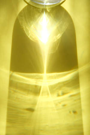 Yellow colored abstract background with light and shadows caustic effect. Light passes through a...