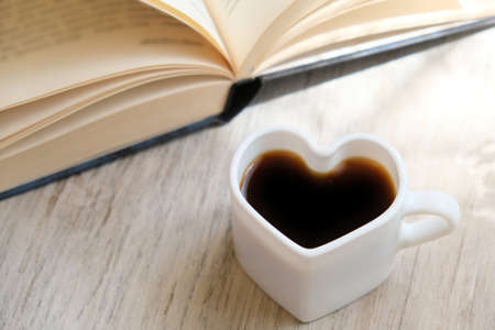 Blurred background of morning still life, coffee in bed. White cup in shape heart and fluffy scarf....
