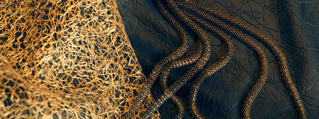 Beautiful layers of delicate golden mesh and black fabric background with elegant female jewelry