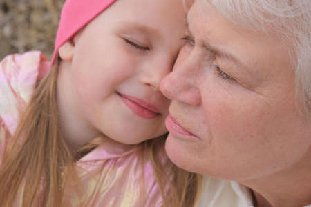 Close up portrait of grandmother and granddaughter. Having good times with grandparent outdoorsの写真素材