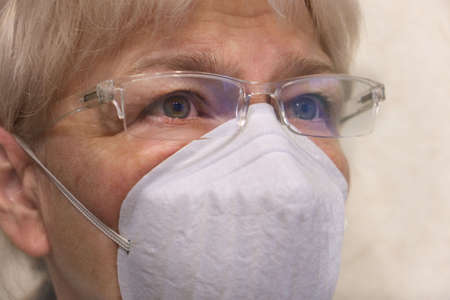 Close up senior woman wearing glasses and face mask during corona virus and flu outbreak. Disease...
