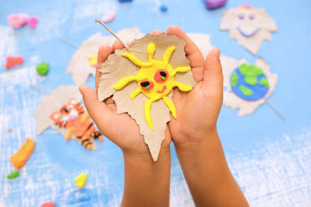 Child made sun from plasticine. Ecology concept. Concept of art learning and education, save worldの写真素材