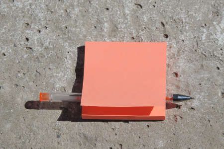 blank orange sticker forms with place for text, pen, concrete peeling surface