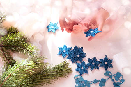 Child girl preparing winter holidays and Christmas at home. She sitting on floor and playing with Christmas toys.の写真素材