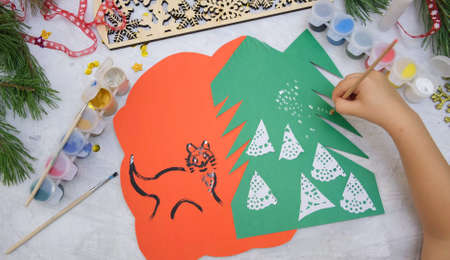 Child making a greeting card Craft for children. Nice greeting card with a Christmas snowy forest. ... Top viewの写真素材