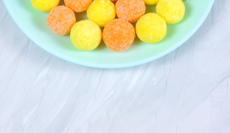 Glazed peanuts of different colors on a plate, white background. Multicolored peanuts. close-up. Snack colored kernel, hazelnut, nut.の写真素材