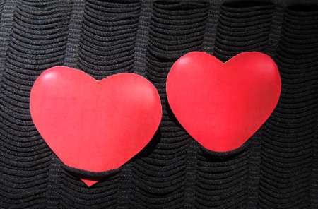 two red hearts on embossed knitted fabric in blackの写真素材