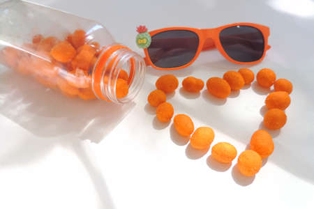 heart shaped peanuts in orange glaze , sunlight and shadow, selective focus