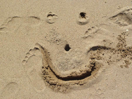 smiling face is drawn in the sandの写真素材