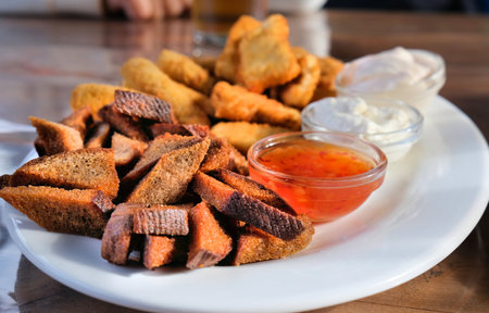 Fast food, Fresh beer snacks assortment. fried rye bread croutons and cheese sticks with sauces,...
