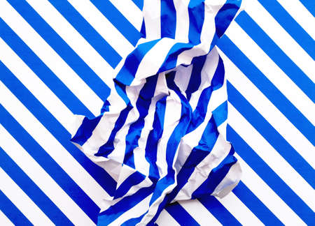 A lump of crumpled striped blue and white paper on striped background. For web page design.
