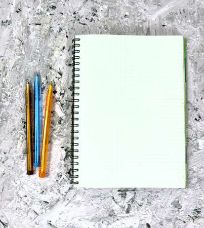 mock up  notepad blank sheet for message colored pens on textured abstract background