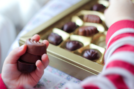the child takes candy.Closeup view of box of chocolates.の写真素材