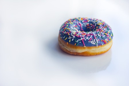 sweet Donut with icing and color dusting, on a white background, top viewの写真素材
