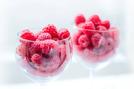 Raspberry berries close-up. juicy fresh berries in summer. healthy food. berries are portioned out in glass glasses. selective soft focus.の写真素材