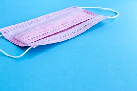 Pink medical mask, Medical protective mask on blue background. Coronavirus hygiene conceptの写真素材