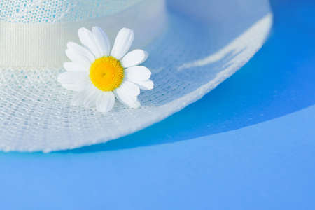 summer straw hat and daisy flowers on blue background. Summertime season, Vacation, weekend relax conceptの写真素材