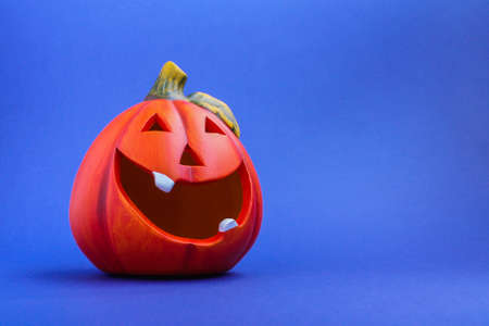 bright orange pumpkin lantern on a blue background. the concept of Halloween.の写真素材