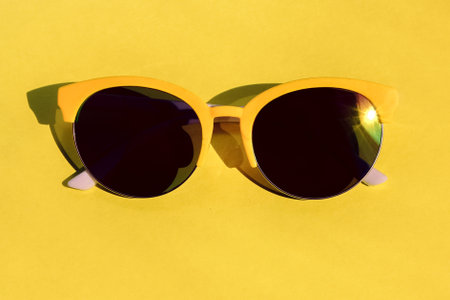 yellow-framed sunglasses on a yellow background. fun summer accessories for adults and children.の写真素材