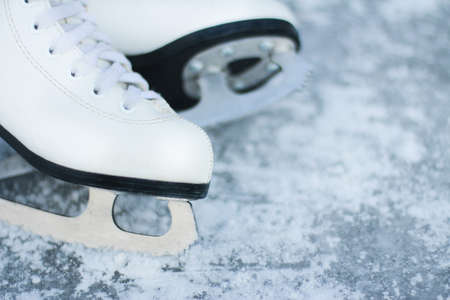 close-up of figure skates on an ice background. Ice skating outdoor activities with the family in winterの写真素材