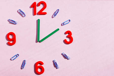 study the topic of hours with children. The watch is made of numbers, paper clips, and sticks from a children learning kit.の写真素材