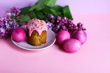 bright purple easter eggs, cake and lilac flowers on a purple background. Easter decor. Selective focusの写真素材