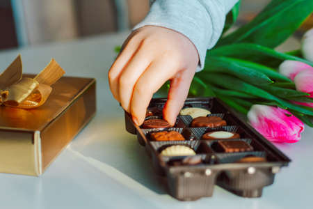 the child takes chocolates from a gift boxの写真素材