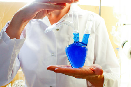 a chemist with a heart-shaped flask. analytical, research work in the laboratory, the formulation of new syntheses and the production of new synthetic substances. the concept of love for chemistry.の写真素材