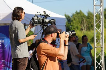 St. Petersburg, June 21, 2014: a professional photographer with a SLR camera and a male videographer with a video camera shoot a public outdoor eventのeditorial素材