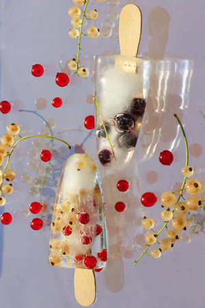 currant berries in ice, frozen in the form of ice cream on a stick. summer refreshing food