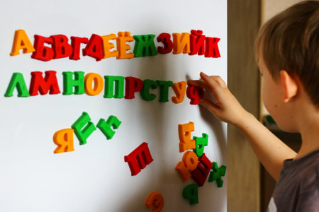 the child is playing with the letters of alphabet. Intellectual play, preschool primary educationの写真素材