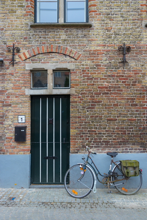 Bicycle in front of an old house in Bruges, Belgiumの写真素材